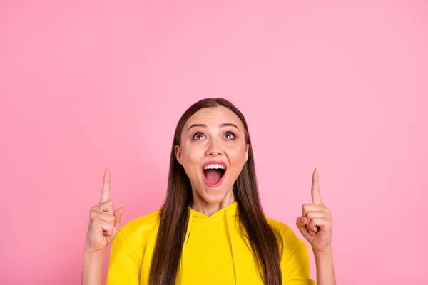 Photo of cheerful cute casual nice charming trendy white girlfriend shouting to you about sales and discounts pointing up at them wearing yellow sweatshirt isolated over pink pastel color background — Stock Photo, Image