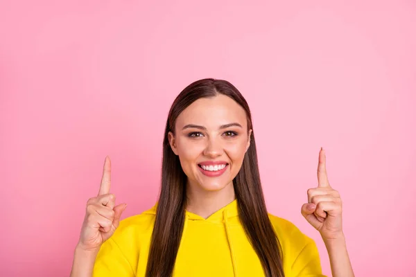 Close up foto de encantadora bela namorada atraente apontando para algo notificado acima vestindo camisola amarela, enquanto isolado com fundo cor pastel rosa — Fotografia de Stock