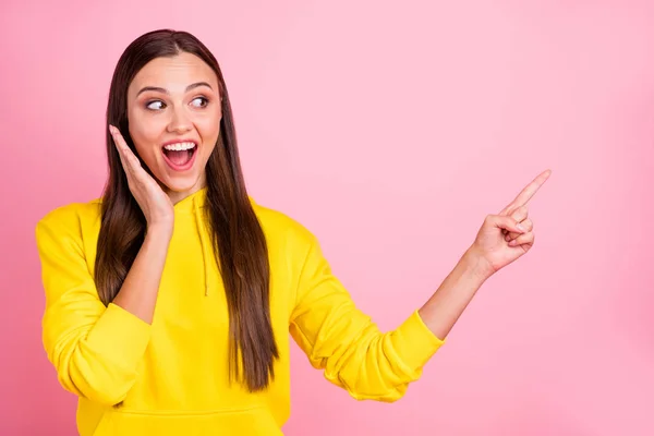 Foto av charmiga söta vackra attraktiva underbara flickvän bär levande gul Tröja pekar på något bort från hennes glädje medan isolerade med pastell färg rosa bakgrund — Stockfoto