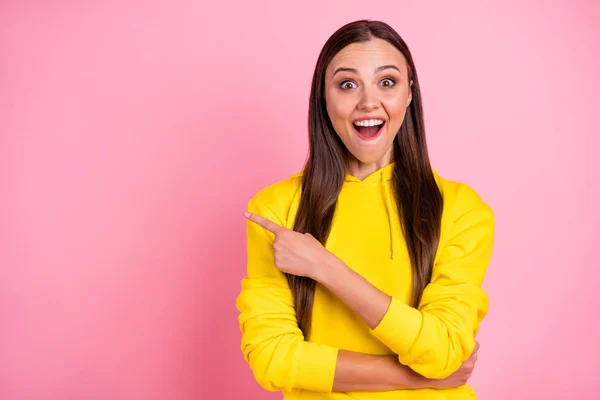 Foto de encantador bonito agradável alegre linda linda namorada apontando para algo que tem que ser subscrito vestindo capuz amarelo isolado com fundo de cor pastel rosa — Fotografia de Stock