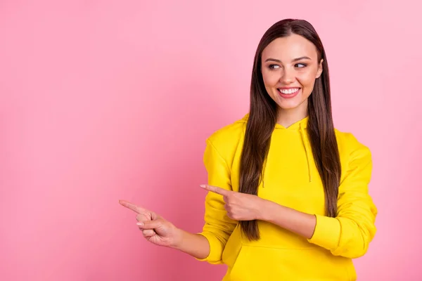 Potret gadis hipster pintar yang cukup pintar dengan pakaian cerah yang menunjuk pada ruang kosong latar belakang warna pastel yang terisolasi — Stok Foto