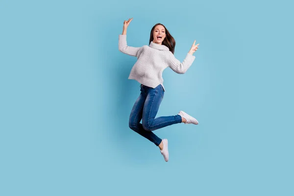 Full längd foto av innehåll uppriktig flicka hoppa har ledig tid göra v-skyltar känner galen slitage denim jeans vit Pullover vita sneakers isolerade över blå färg bakgrund — Stockfoto