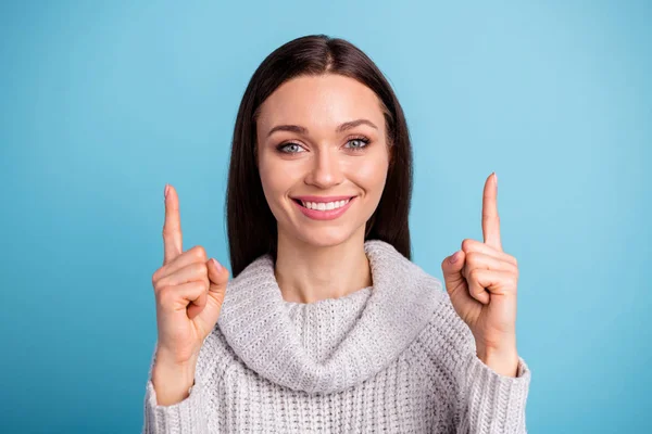 Närbild foto av positiv glad tjej promotor Välj annonser Bestäm annonser slå upp punkt pekfinger slitage vit stickad tröja isolerad över blå färg bakgrund — Stockfoto