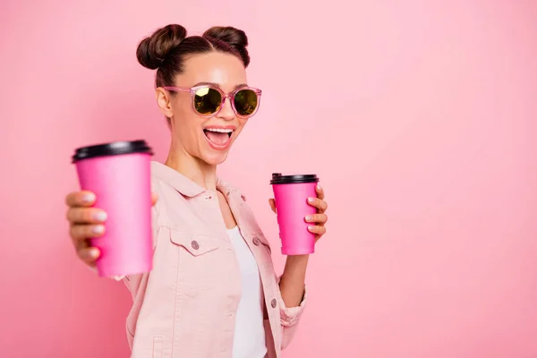 Retrato de senhora alegre em óculos óculos segurando caneca bebida dando vestindo casaco isolado sobre fundo rosa — Fotografia de Stock