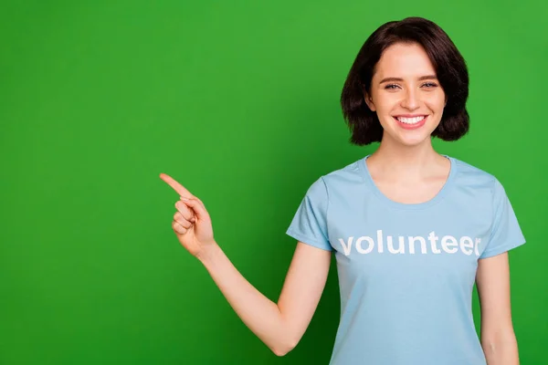 Close-up portrait of her she nice attractive lovely cheerful cheery content girl wearing blue t-shirt pointing at copy space subscribe isolated over bright vivid shine vibrant green background — Stock Photo, Image