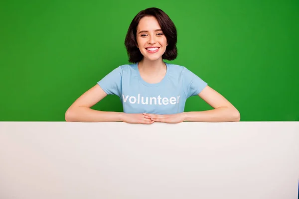 Retrato dela ela agradável atraente alegre alegre feliz conteúdo menina vestindo azul t-shirt mais copyspace anúncio vaga contratação isolado sobre brilhante vívido brilho vibrante fundo verde — Fotografia de Stock