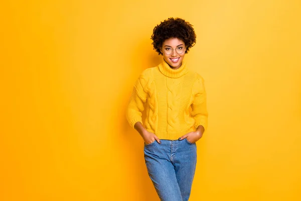 Photo of charming cute cheerful pretty beautiful girlfriend smiling toothily holding hands in pockets wearing jeans denim pullover isolated with vivid color yellow background — Stock Photo, Image