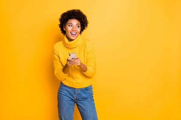 Copyspace fénykép bájos aranyos szép gyönyörű lenyűgöző vonzó blogger fekete hölgy viselt farmer denim jumper örvendezve az új telefon a kezében elszigetelt át élénk színű háttér — Stock Fotó