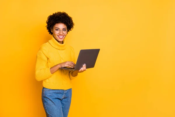 Copyspace photo of attractive intelligent cheerful business black stylish beautiful woman holding lap top with hands browsing through wearing yellow pullover isolated vivid color background — Stock Photo, Image