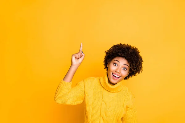 Fotó a sötét bőr vicces hölgy jelzi ujját fel üres helyet eladó plakát kopás meleg kötött áthidaló elszigetelt sárga háttér — Stock Fotó