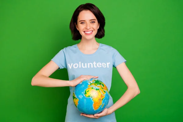 Retrato dela ela agradável atraente encantador encantador alegre menina vestindo azul t-shirt segurando as mãos em volta do globo isolado sobre brilhante vívido brilho vibrante fundo verde — Fotografia de Stock