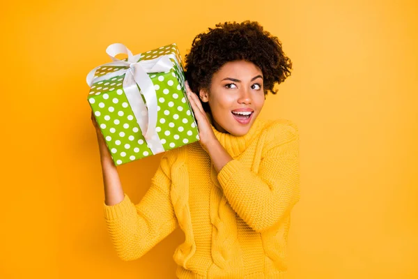 Foto de casual alegre encaracolado moda confuso namorada ouvir envolto caixa parte interna vestindo suéter amarelo confuso expressão facial isolado com fundo de cor vívida — Fotografia de Stock