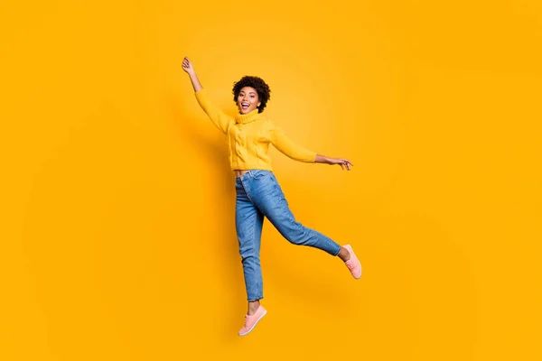 Full längd kroppsstorlek foto av lockigt charmig Söt flickvän känsla gratis bär Jeans denim gul Tröja skor hoppar upp flyger bort isolerade levande färg bakgrund — Stockfoto