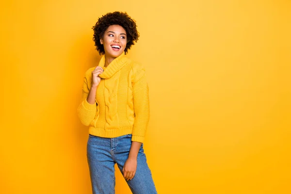 Foto de pele escura senhora engraçada em bom humor desgaste quente de malha jumper e jeans de pé isolado fundo amarelo — Fotografia de Stock