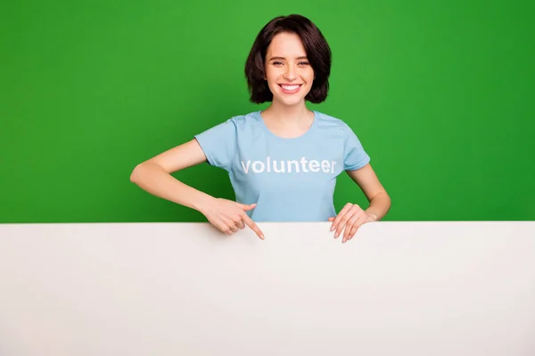 Retrato dela ela agradável atraente alegre alegre menina confiante vestindo azul t-shirt apontando para cópia vazio espaço vazio lugar isolado sobre brilhante vívido brilho vibrante fundo verde — Fotografia de Stock