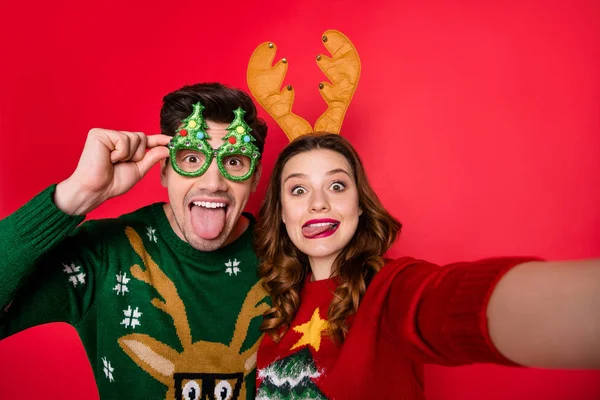 Foto van kinderachtig Lady en Guy bij x-mas kostuum partij maken selfies slijtage lelijke gebreide truien geïsoleerd rode kleur achtergrond — Stockfoto