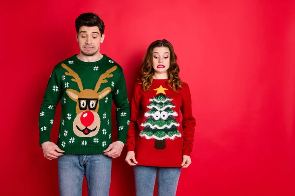 What disgust. Portrait of frustrated two brunette haired students stare at deer christmas tree design jumper displeased wear stylish trendy jeans denim isolated over red color background — Stok fotoğraf