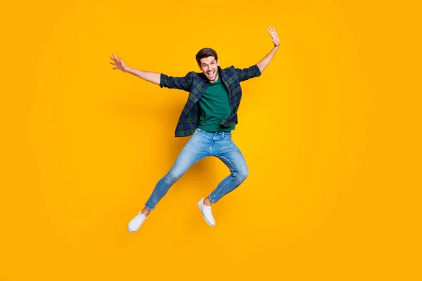 Foto em tamanho completo de satisfeito animado homem entusiasta saltar desfrutando de tempo livre em feriados roupas de boa aparência moderna roupa da moda isolado sobre fundo de cor amarela — Fotografia de Stock