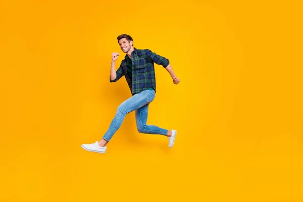 Full längd kroppsstorlek sida profilfoto av glada positiva roliga trendiga killen bär Jeans denim skyndar hoppa upp till försäljning isolerade över levande färg gul bakgrund — Stockfoto