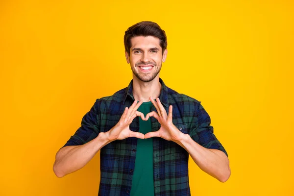 Photo of amazing guy making arms heart romance invitation to students prom wear casual plaid shirt isolated yellow color background — Stock fotografie