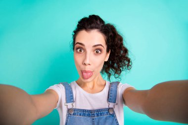 Self-portrait of her she nice attractive charming lovely winsome cheerful cheery wavy-haired girl wearing casual showing tongue out fooling isolated on bright vivid shine green turquoise background clipart