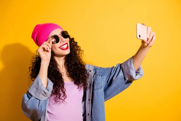 Foto de senhora elegante segurando telefone na mão fazendo selfies usar roupas casuais e especificações do sol isolado cor amarela fundo — Fotografia de Stock
