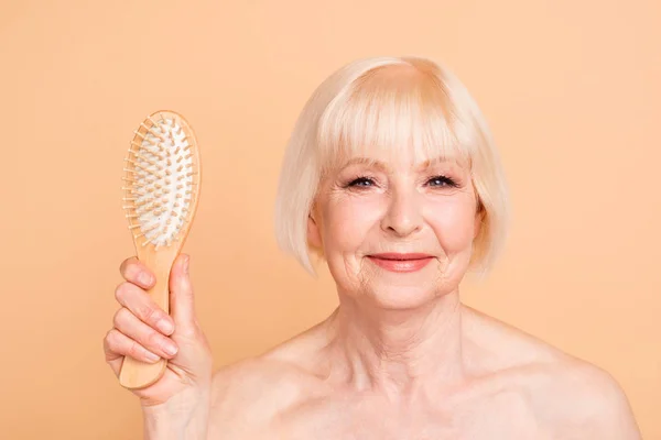 Primer plano retrato de ella ella ella atractivo desnudo desnudo bien cuidado confiado tranquilo brillo señora de pelo gris mostrando nuevo peine de masaje aislado sobre fondo beige — Foto de Stock