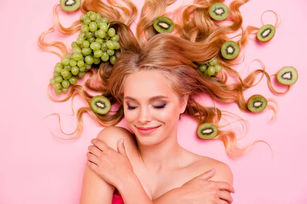 Cierre por encima de la vista de ángulo alto foto hermosa que su señora toque la piel suave paraíso acostado de las frutas de uva kiwi largos rizos procedimiento de estilo de vida saludable siesta de fondo rosa aislado —  Fotos de Stock