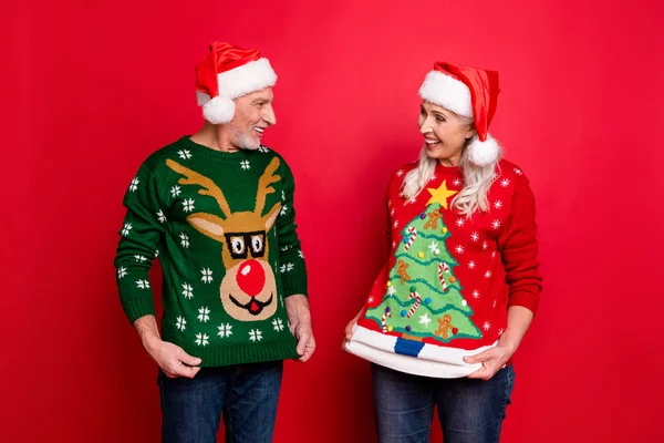 December you are crazy concept. Two excited cheerful positive nice glad friends husband wife people showing each other funky motley comic pictures of reindeer on jumpers isolated color background — Stock Photo, Image