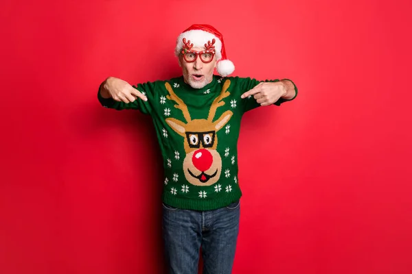 Såg du detta. Foto av glada upphetsad skäggiga Grey-haired Guy visar Rudolf med röd näsa på hans funky stil december Grön Retro stickad tröja Pullover isolerad ljus färg bakgrund — Stockfoto