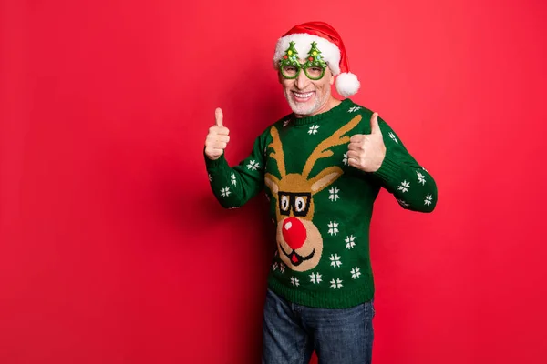 Everything will be fine. Photo of handsome with toothy smile excited positive guy making double fingers up enjoying decorations tree x-mas tradition spirit isolated vibrant background — Stock Photo, Image