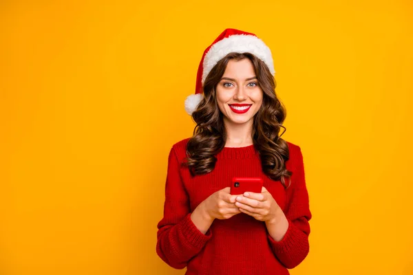 Photo of amazing lady holding telephone in hands wear knitted pullover and santa hat isolated yellow background — Stock Photo, Image