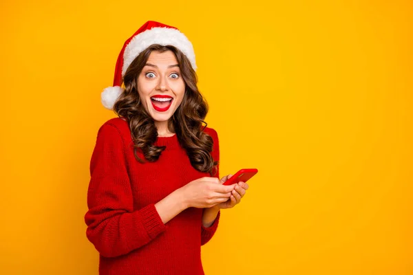Photo of crazy lady holding telephone in hands wear knitted pullover and santa hat isolated yellow background — Stock Photo, Image