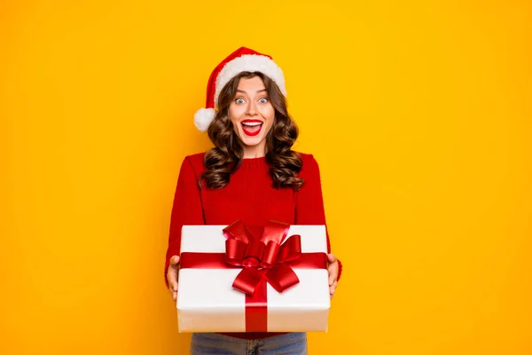 Vacker dam håller stora giftbox i händerna slitage stickad tröja och Santa hatt isolerad gul bakgrund — Stockfoto