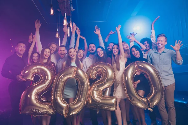 Niza atractivo glamoroso elegante alegre positivo niñas y chicos se divierten llevando en las manos grandes números celebratorio 2020 fiesta estado de ánimo en lugar de lujo discoteca en el interior —  Fotos de Stock