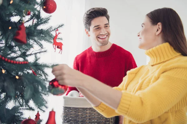 Close up foto de dois cônjuges românticos decorar árvore de Natal com bolas pendurar bugigangas se sentir positivo em férias de ano novo em casa com grinaldas enfeites x-mas — Fotografia de Stock