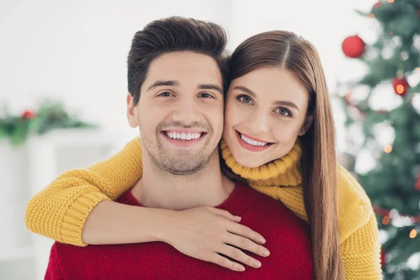 De cerca la foto de dos personas románticas alegres positivas abrazo a cuestas disfrutar de la fiesta de Navidad se siente vínculo afectuoso en casa con adorno de año nuevo en el interior — Foto de Stock