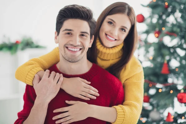 Cerca de la foto de dos cónyuges personas tienen romance disfrutar de vacaciones de Navidad nuevo año fiesta abrazo a cuestas en casa con adorno de Navidad en el interior —  Fotos de Stock