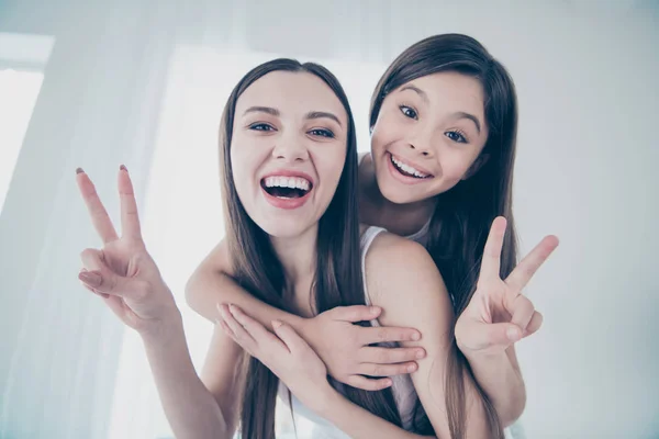 Gros plan portrait de deux belles belles jolies joyeux joyeux joyeux drôle funky heureux excité personnes aux cheveux longs passer du temps libre montrant v-signe dans la pièce intérieure blanc clair — Photo