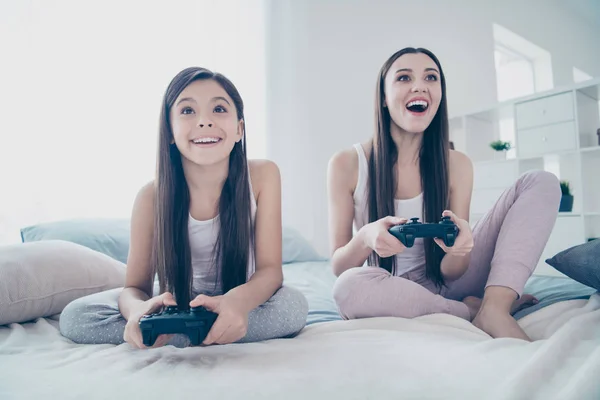 Portret van twee mooi uitziende mooie aantrekkelijke mooie charmante schattig vrolijk vrolijke vrolijk langharig positieve mensen spelen PlayStation Battle amusement in lichte witte interieur kamer binnenshuis — Stockfoto