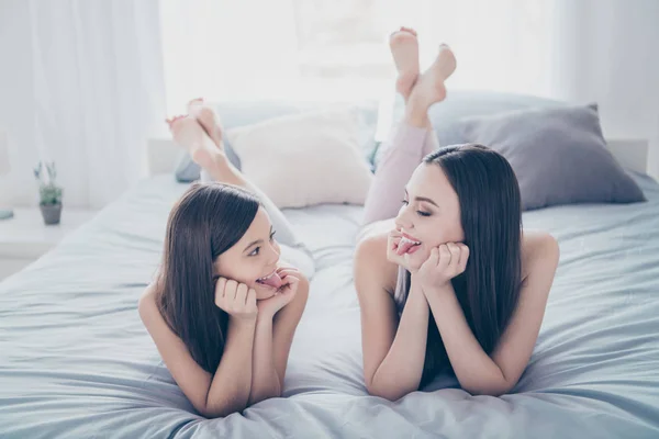 Portret van twee mooie mooie aantrekkelijke ondeugende meisjesachtig vrolijke vrolijke mensen liggen uitgaven vrije tijd weekend goed humeur Daydream emotie rest ontspannen in licht wit interieur huis — Stockfoto