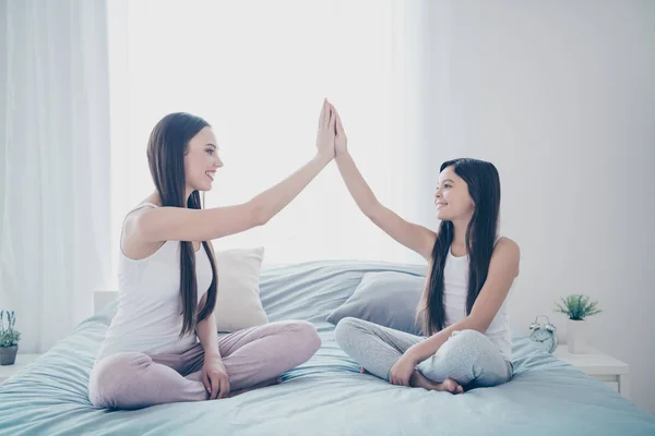 Portret van twee mooie mooie aantrekkelijke mooie vrolijke vrolijk vrolijke vriendelijke mensen zittend op bed in Lotus pose klappen Palms deal gedaan overeenkomst in licht wit interieur huis binnenshuis — Stockfoto