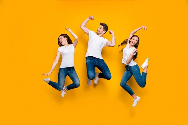 Full length body size view of three nice attractive lovely slim strong sporty cheerful cheery person having fun free time isolated over bright vivid shine yellow background — стоковое фото