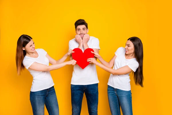 Retrato de dois agradável atraente adorável adorável competitivo irritado fúria namoradas tomando puxando um coração concurso família desejo isolado mais brilhante vívido brilho amarelo fundo — Fotografia de Stock