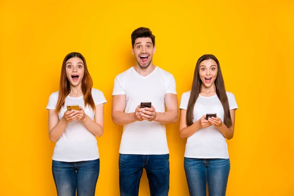 Portrait de trois belle belle allure séduisante gai joyeux heureux personne utilisant wi-fi connexion vitesse 5g app temps libre isolé sur fond jaune brillant vif — Photo