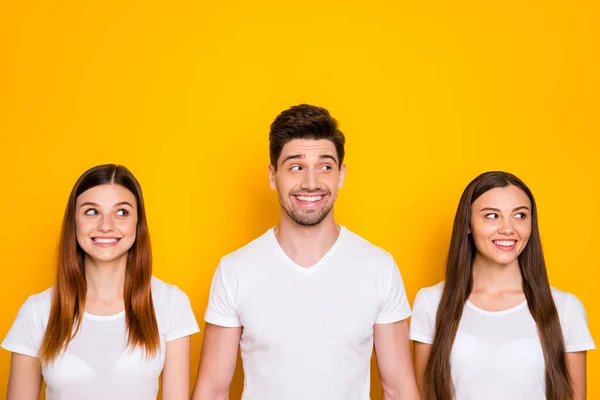 Retrato de amigos bonitos olhando ter o sorriso dos dentes vestindo t-shirt branca isolada sobre fundo amarelo — Fotografia de Stock