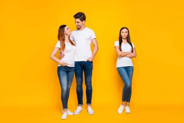 Volle Größe phot von mürrischen Mädchen, die auf Lieblinge kuscheln tragen weiße T-Shirts Jeans isoliert über gelbem Hintergrund — Stockfoto