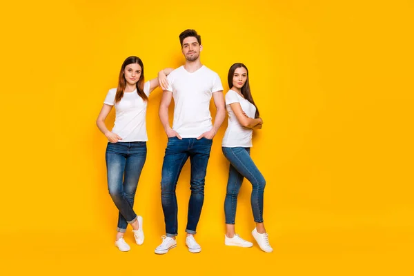 Foto in voller Größe von coolen Hipster mit langen Haaren, die ihre Hände gefaltet tragen weiße T-Shirt Jeans isoliert über gelbem Hintergrund — Stockfoto