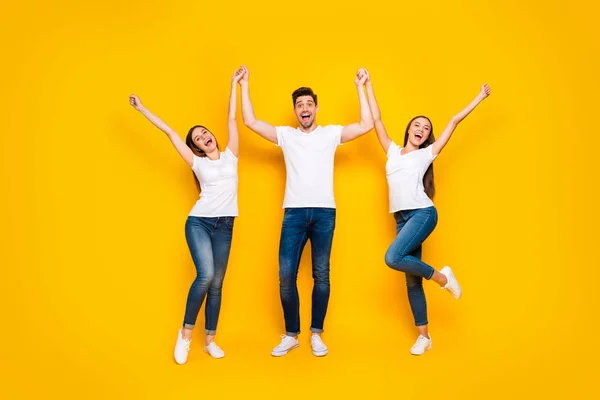 Foto em tamanho completo de conteúdo companheiros levantando as mãos gritando em pé isolado sobre fundo amarelo — Fotografia de Stock