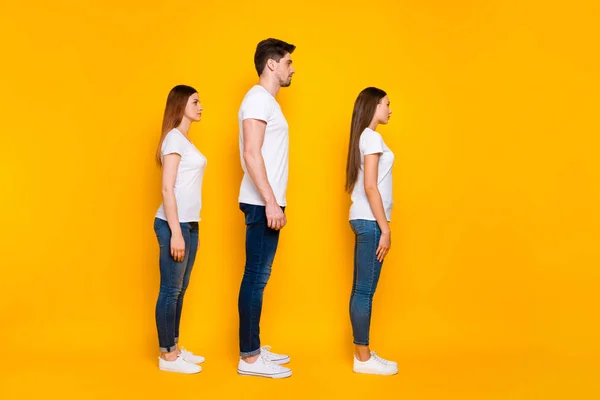 Foto lateral de perfil de longitud completa de los jóvenes enfocados que lucen pantalones vaqueros blancos con camiseta aislados sobre fondo amarillo —  Fotos de Stock